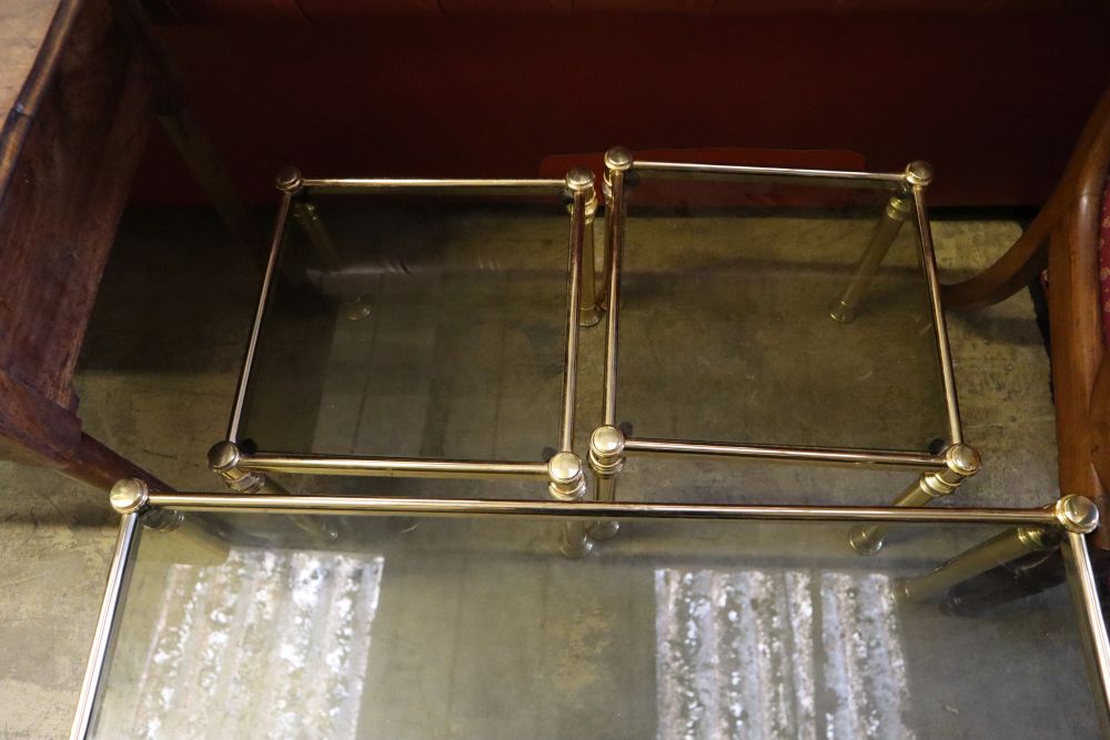A nest of three brass and smoked glass tea tables, width 90cm depth 50cm height 44cm